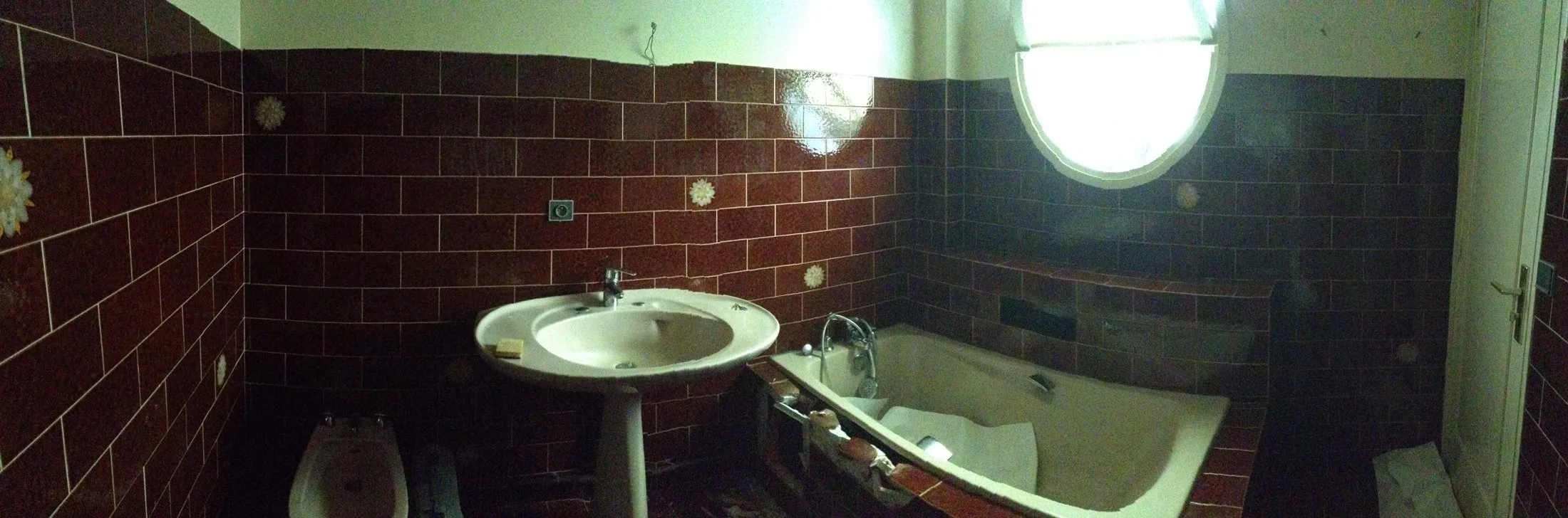 Salle de bain avant rénovation, carrelage rouge foncé